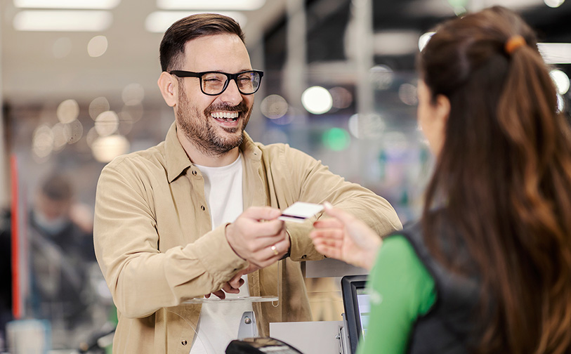 Card being inserted into a payment terminal by a worker at a jewellery store checkout counter