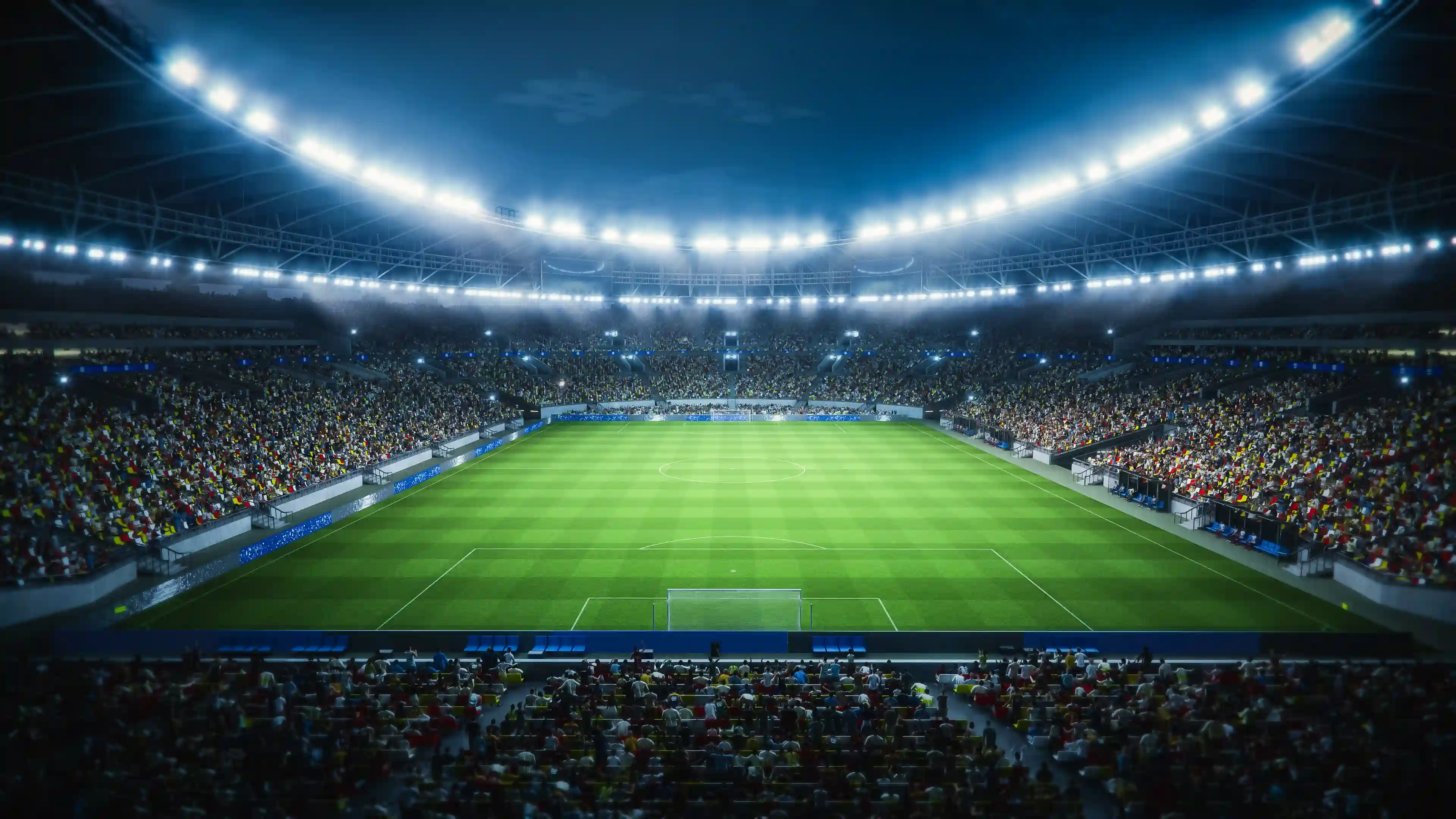 Large illuminated football stadium filled with spectators and bright lights surrounding the roof with a well maintained field and soccer markings
