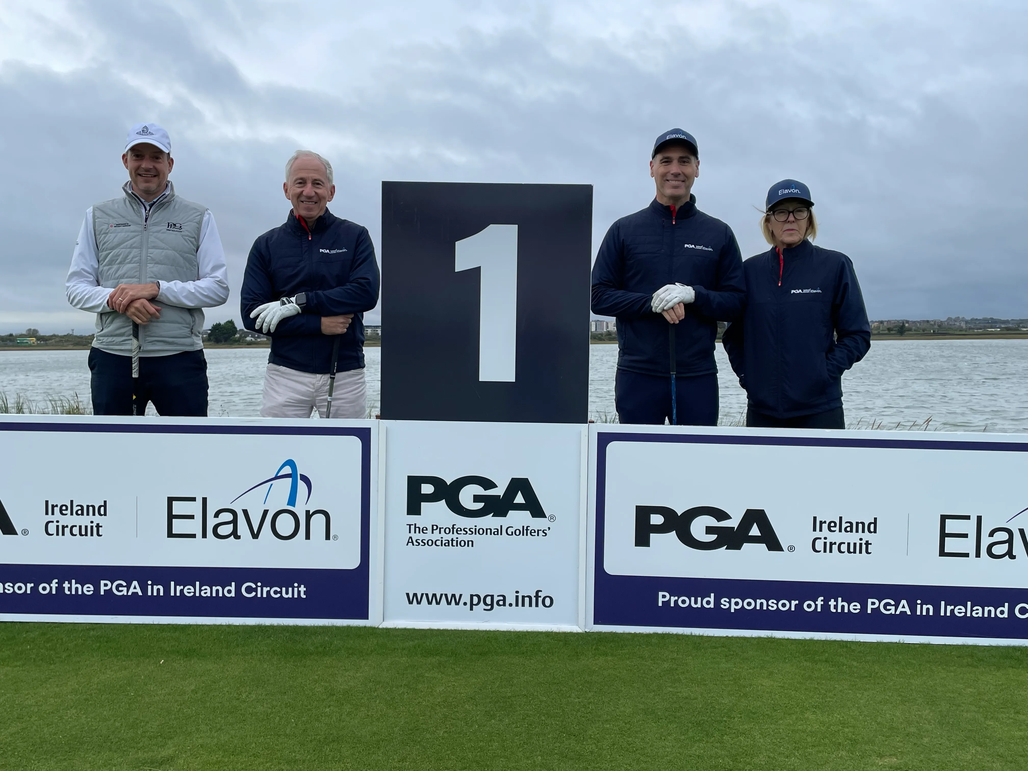 Golfers at PGA Ireland Circuit tee marker one with Elavon sponsorship board on a scenic golf course.